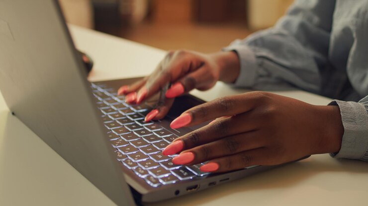 Foto gratuito mujer escribiendo información en una computadora portátil, trabajando para resolver tareas de proyectos web en casa. bloguero afroamericano escribiendo una historia para un trabajo de teletrabajo, desarrollador autónomo. de cerca.