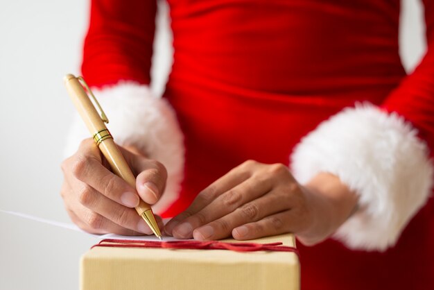Mujer escribiendo nota para regalo de navidad