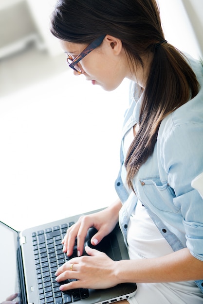 Foto gratuita mujer escribiendo en su ordenador portátil