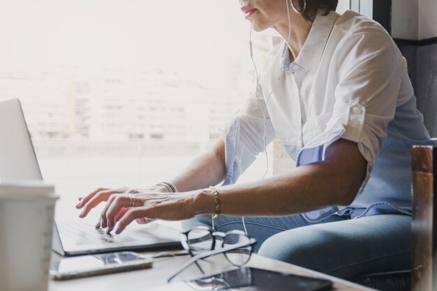 Mujer escribiendo en el teclado del ordenador portátil