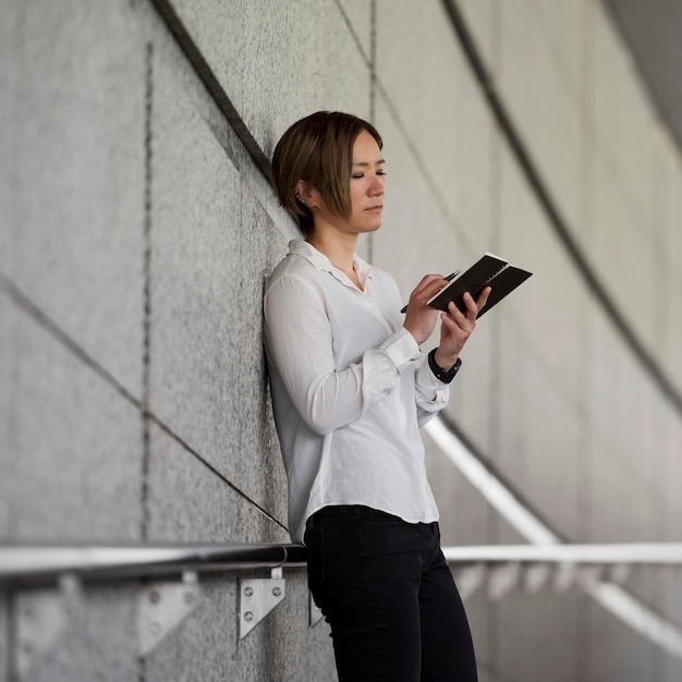 Foto gratuita mujer escribiendo en tiro medio portátil