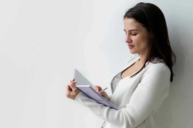 Mujer escribiendo en tiro medio portátil