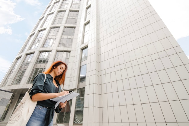 Mujer, escritura, papeles, edificio