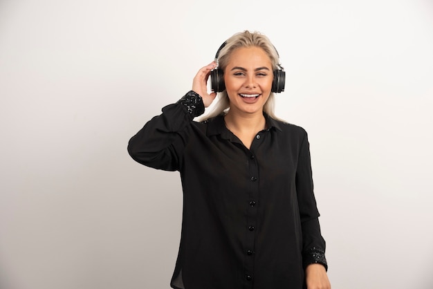 Mujer escuchando la canción con auriculares sobre fondo blanco. Foto de alta calidad