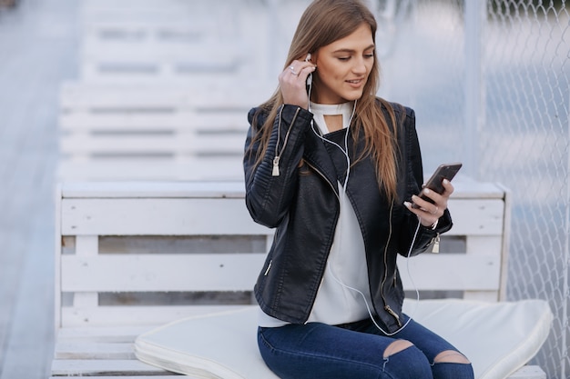 Mujer escuchando música con auriculares blancos