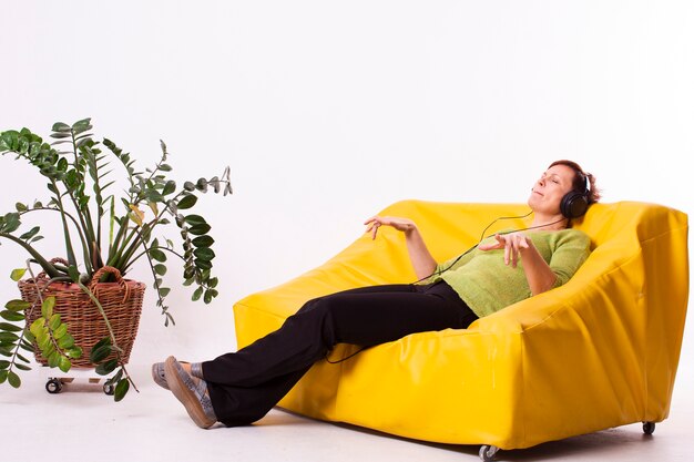 Mujer escuchando música y descansando en el sofá