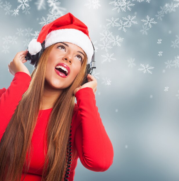 Mujer escuchando música con fondo navideño