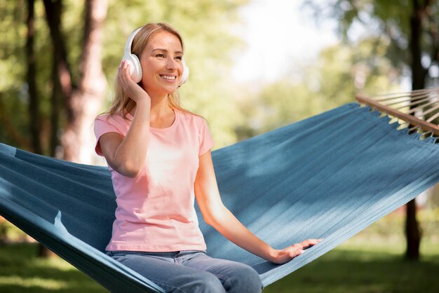 Mujer escuchando música en una hamaca a largo plazo