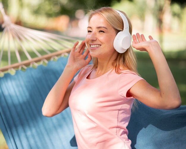 Mujer escuchando música en una hamaca