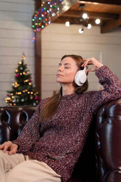 Mujer escuchando música navideña en auriculares