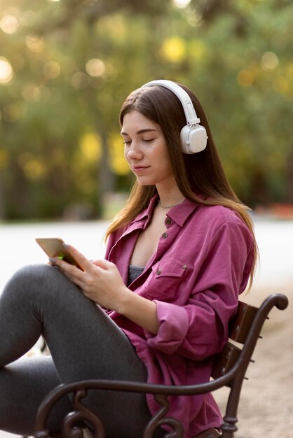 Mujer escuchando música en el parque