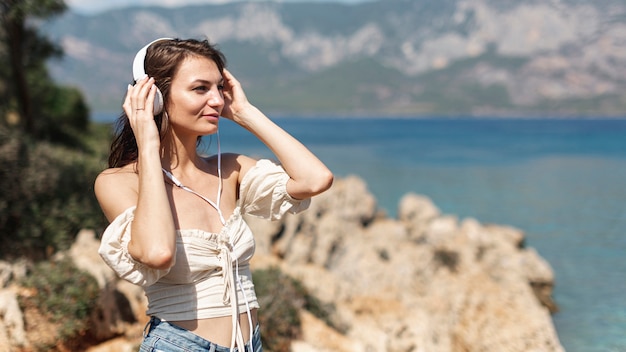 Foto gratuita mujer escuchando música en la playa