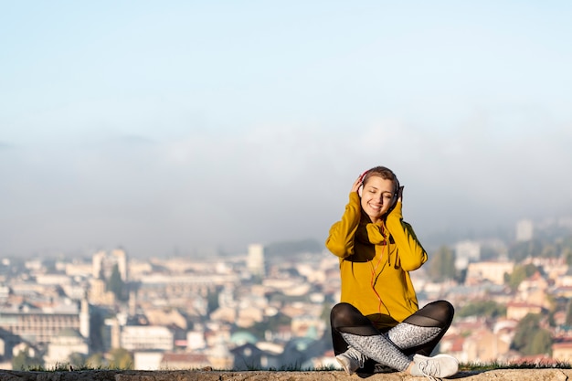 Foto gratuita mujer escuchando música tiro completo