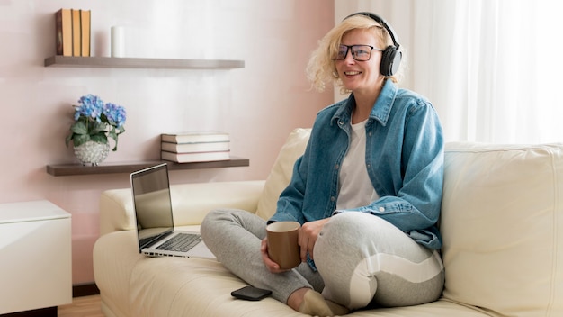 Mujer escuchando música y tomando café