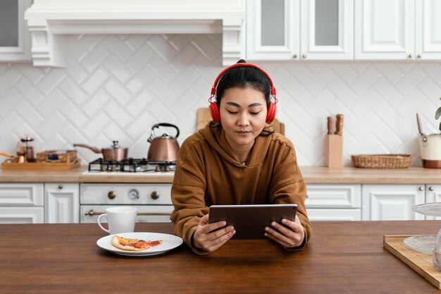 Mujer escuchando videos en línea en tableta