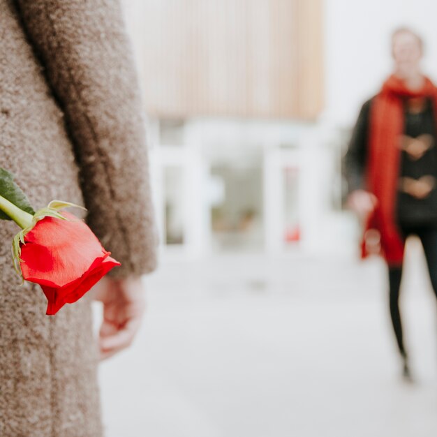 Mujer esperando novio con rosa