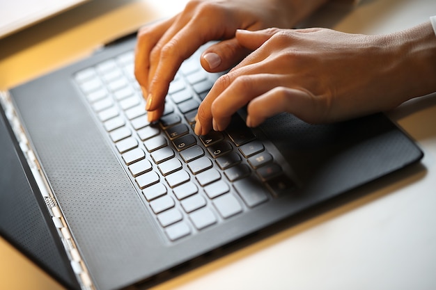 Mujer está escribiendo en una computadora portátil