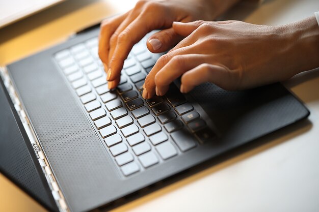 Mujer está escribiendo en una computadora portátil