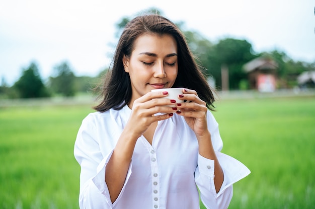 mujer estaba felizmente tomando café en el prado