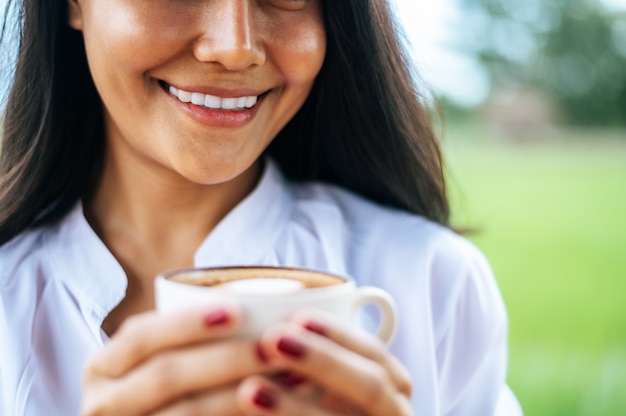 mujer estaba felizmente tomando café en el prado