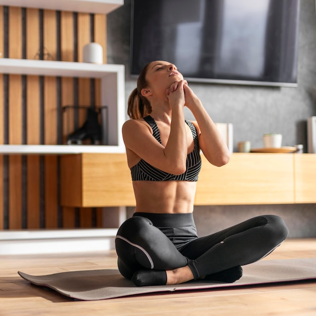 Mujer en estera de yoga full shot