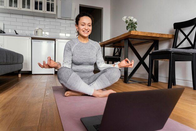 Mujer en estera de yoga full shot