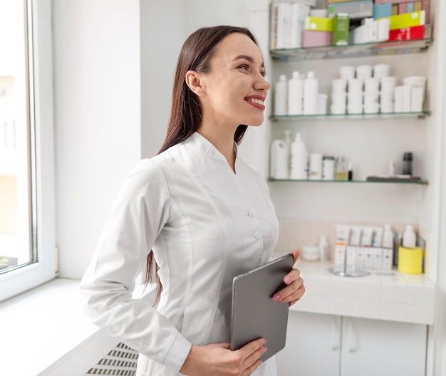 Mujer esteticista en clínica con tableta
