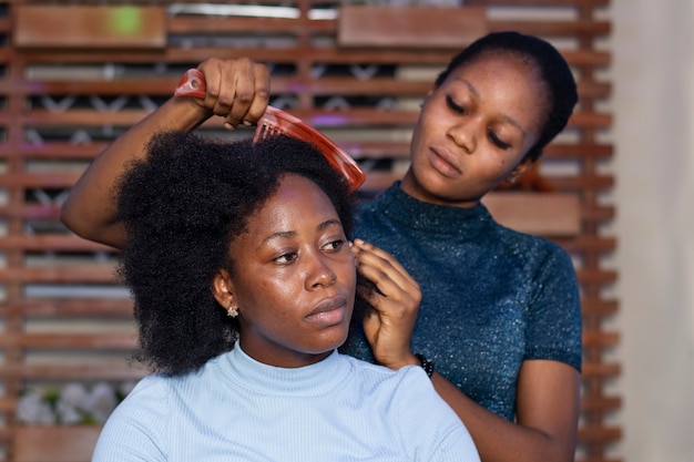 Mujer estilista cuidando el cabello afro de su cliente