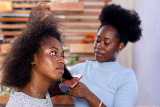 Foto gratuita mujer estilista cuidando el cabello afro de su cliente