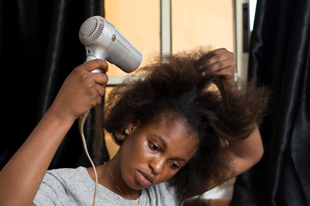 Mujer estilista cuidando el cabello afro de su cliente