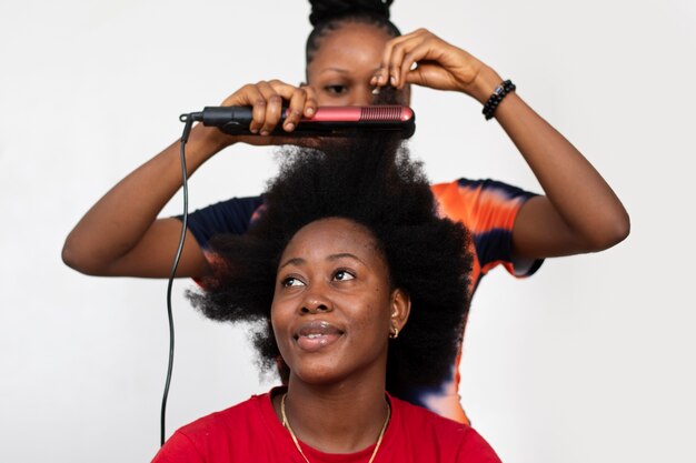 Mujer estilista cuidando el cabello afro de su cliente