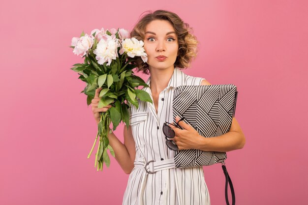 Mujer con estilo atractivo en elegante vestido de rayas blancas con bolso y ramo