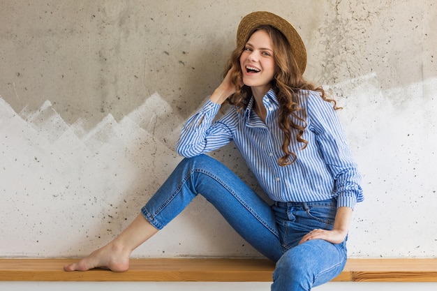 Mujer con estilo atractivo joven sentado en la pared