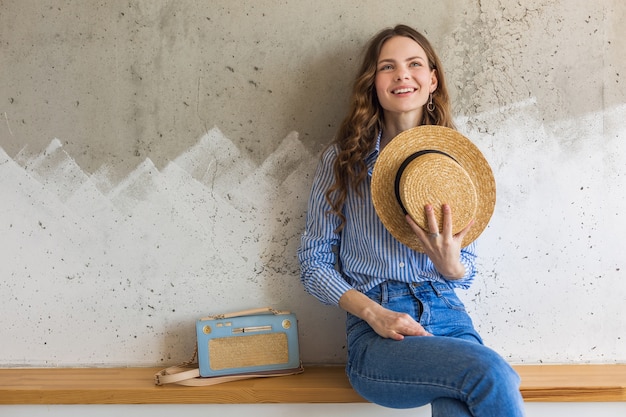 Foto gratuita mujer con estilo atractivo joven sentado en la pared