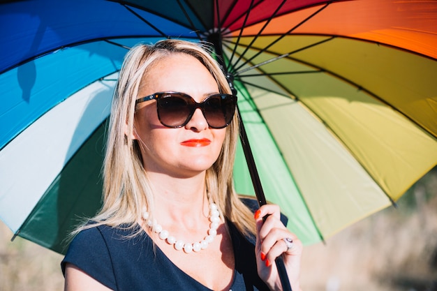 Foto gratuita mujer con estilo con coloridos paraguas al aire libre