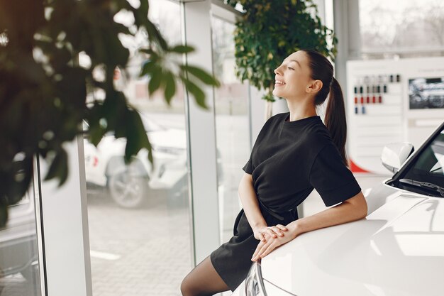 Mujer con estilo y elegante en un salón del automóvil