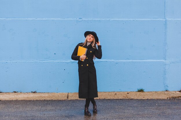 Mujer con estilo enfrente de muro azul