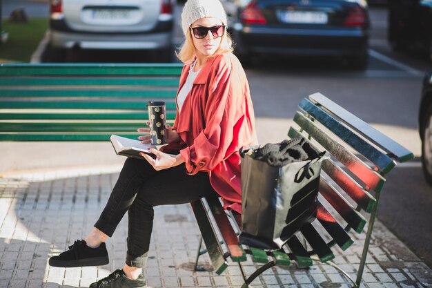 Mujer con estilo con libro y taza