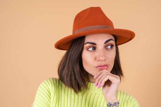 Mujer con estilo de moda en suéter y sombrero posando