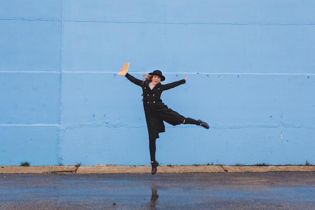 Mujer con estilo posando en frente de un muro azul