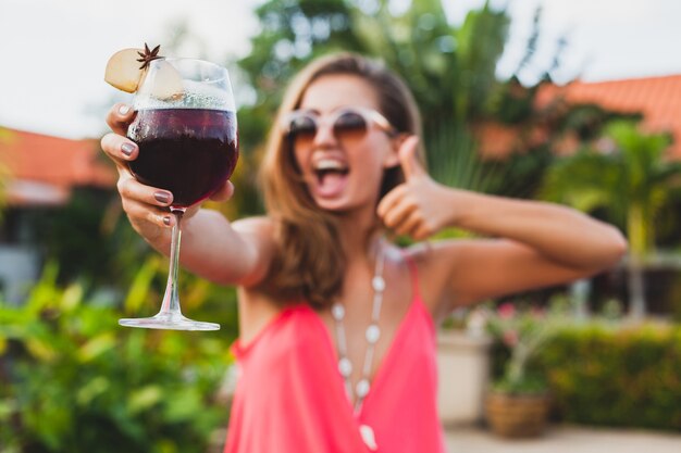 Mujer con estilo sexy en traje de fiesta de moda en vacaciones de verano con copa de cóctel divirtiéndose en la piscina