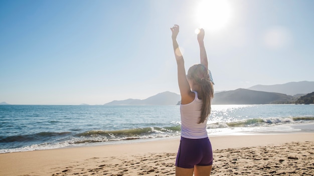 Mujer estirando los brazos en la playa