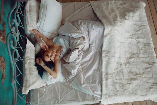 Mujer estirando en la cama después de despertarse