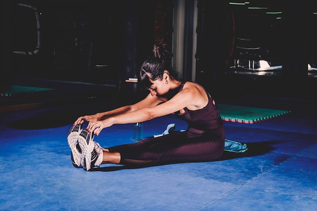 Mujer estirando en gimnasio