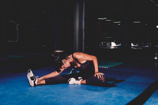 Mujer estirando en gimnasio