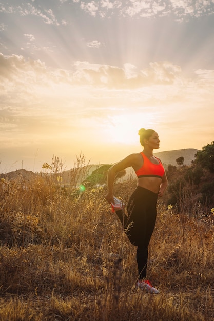 Mujer estirando piernas antes de correr