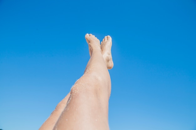 Mujer estirando piernas hacia el cielo