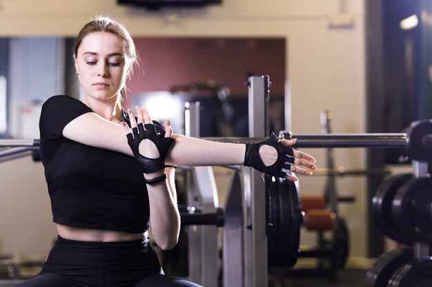 Mujer estirando sus manos en el gimnasio