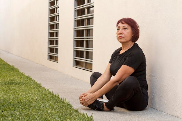 Mujer estirando sus piernas al aire libre