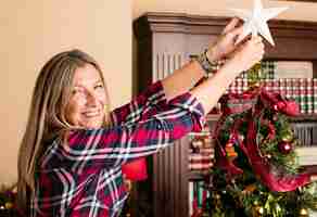 Foto gratuita mujer con una estrella y un árbol de navidad